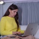 Woman Is Learning Online with the Teacher Using Video Call on Laptop While Sitting on Bed with