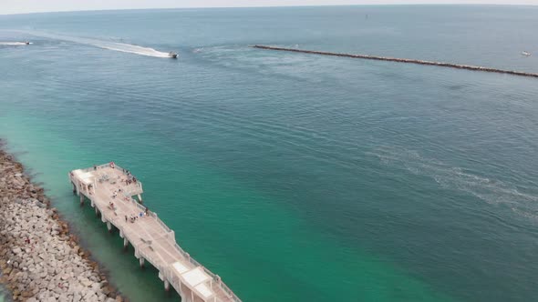 Aerial View of Pier in Ocean and Boat Driving alt