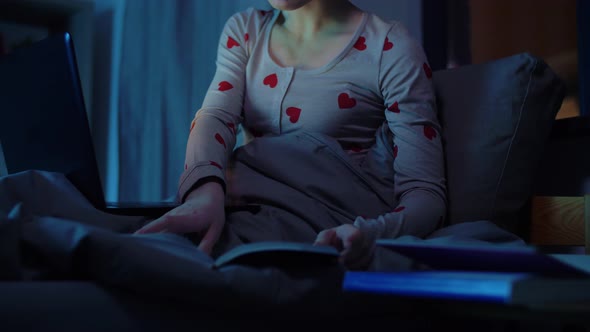 Teenage Girl with Laptop Learning in Bed at Night