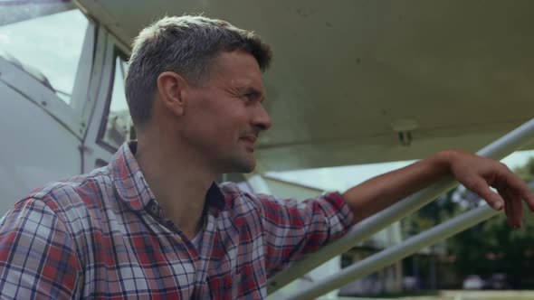 Private Plane Pilot Sitting Near Airplane Smiling After Landing Close Up alt