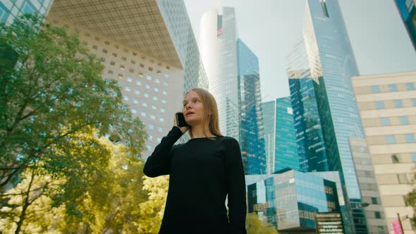 Business Woman Talks By Phone Near Modern Office Buildings in Paris Downtown
