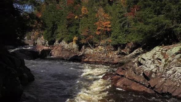 rapids in fall colored forest reveal small waterfalls alt