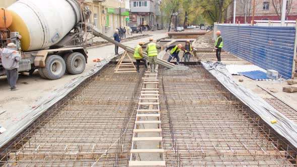 Concrete Works for Road Maintenance Construction Site with Many Workers and Mixer Timelapse alt