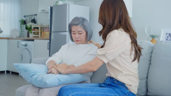 Asian loving daughter consoling and comforts upset stressed elderly mother crying for problem. alt