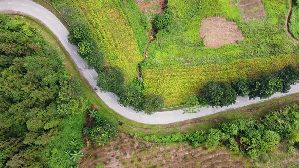 Aerial View Over a Curvy Countryside in the Mountain Road with Moving Motorbikes. alt