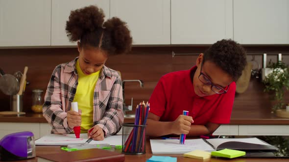 Cute Cheerful Elementary Age African American Siblings Drawing Pictures at Home alt