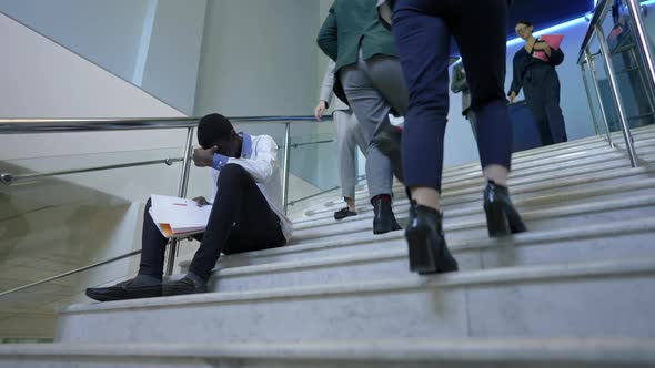 Busy Business People Passing Stressed Overwhelmed African American Man Sitting on Stairs with alt