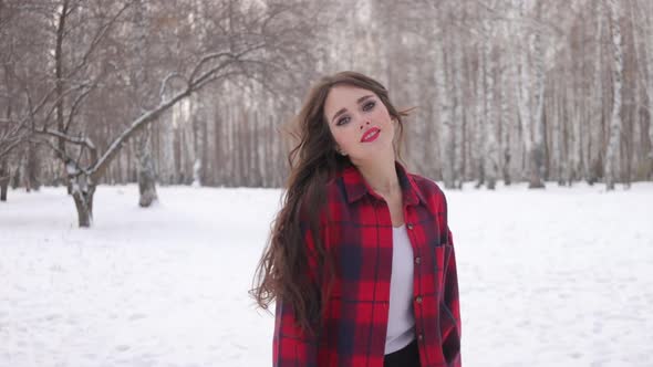 Female in Checkered Shirt Walking in Snowy Park