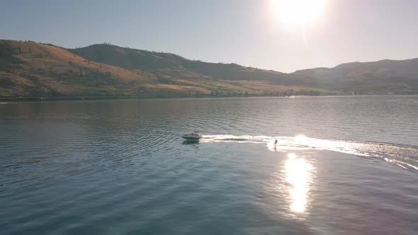Sunny Summer Day Aerial Of Wakeboarding Behind Boat On Lake Chelan alt