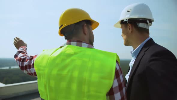 Construction Foreman Talking to Contractor Discussing Project Details Outdoors