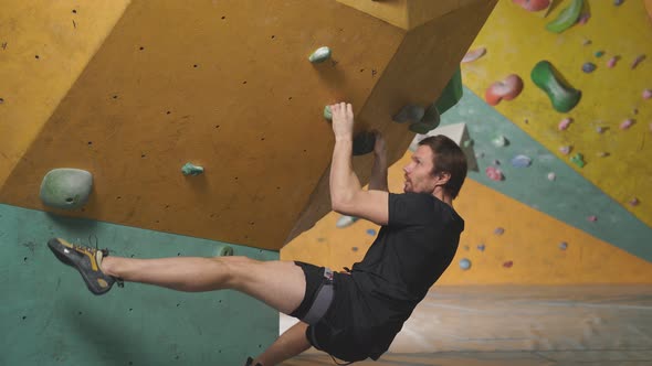 Fit Active Young Man Training at Bouldering Gym Without Special Climbing Equipment