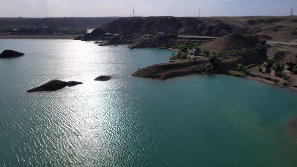 Flying Over a Lake with Islands and Rocks alt