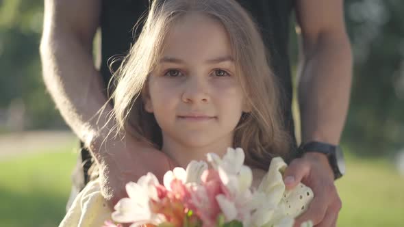 Closeup Front View Confident Pretty Girl Looking at Camera Holding Bouquet of Flowers with Male alt