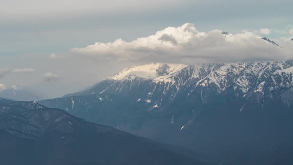 View of Clouds over snowy peaks