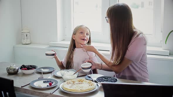 Happy Mom and Daughter Having Breakfast Together