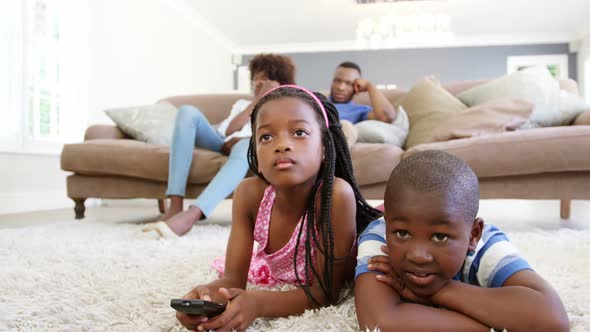 Children watching television in living room alt