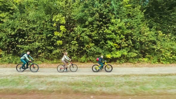 Aerial of family riding bicycles along forest alt