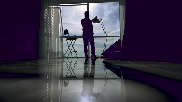 Silhouette of an Young Man That Is Talking at Phone and Walking Inside the Business Building