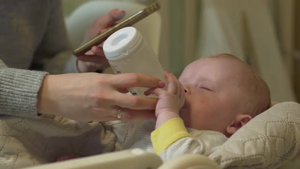 Mother Phone Feeds Baby alt