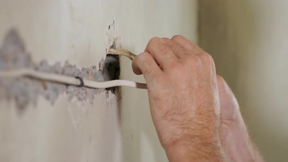 Builder Installing Cords in Wall alt