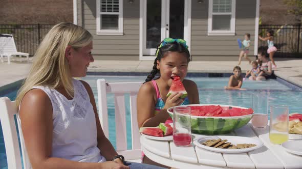 Family having lunch by backyard pool