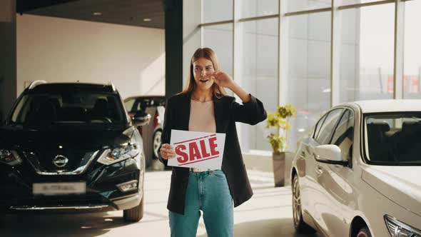 Smiling Caucasian Woman in Casual Clothes Standing at Modern Auto Salon and alt