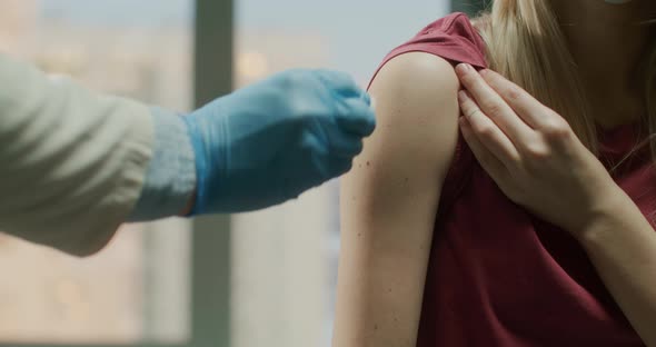 Doctor Making a Vaccine Injection to a Female Patient in a Health Clinic