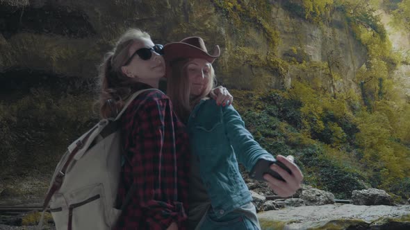 Two Tourists in the Canyon are Photographed on a Smartphone