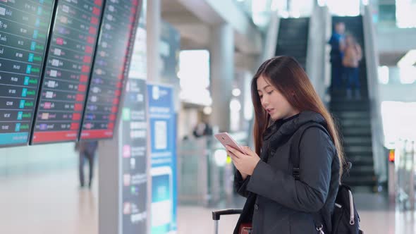 Young traveler female checking flight arrive and departure board