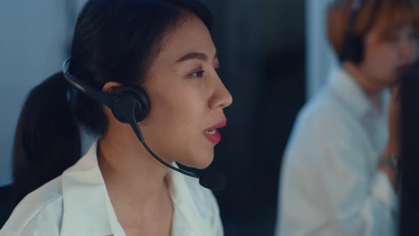 Asia young call center team or customer support service executive using computer and microphone.