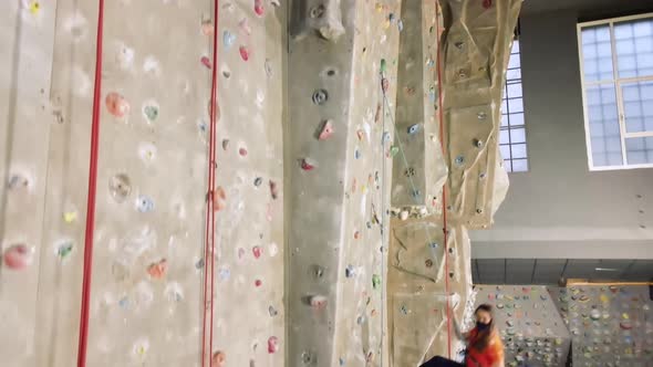 Young Female Athlete Suspended From Climbing Wall in Gym