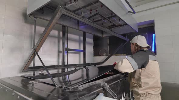 A Male Worker Is Engaged in the Manufacturing Process. A Man Serves the Process of Thermo-vacuum alt