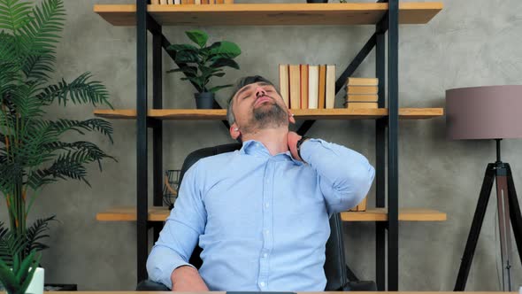 Tired bearded teacher man massaging neck in pain rubs tense muscles after long time hard work laptop