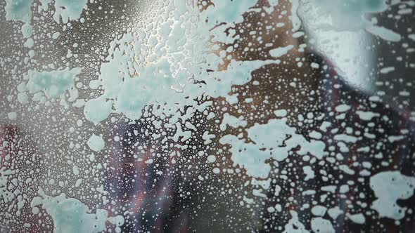 Experienced Housewife Spraying Lot of Washing-Up Liquid on Window to Clean It alt