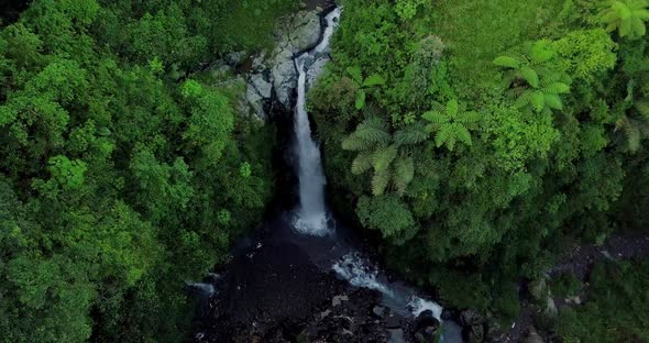 Aerial view from drone flying over nature view of waterfall in the middle of forest. nature is still alt