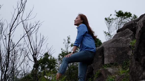 An asian woman hiker enjoy the view at mountain peak