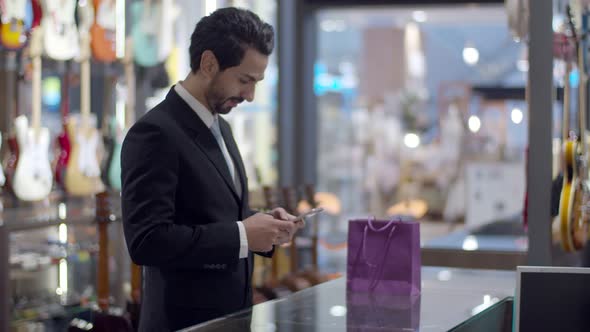 Young handsome man using smartphone and payment by smartphone contactless alt