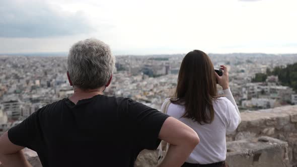 Mature Couple of Tourists Photographs Cityscape