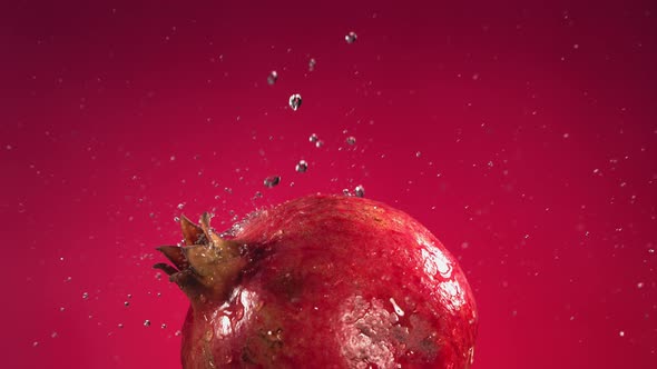 Flying of Pomegranate in Fuchsia Background in Slow Motion alt