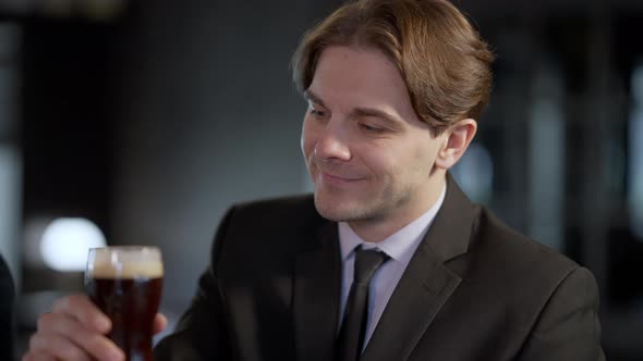 Positive Happy Caucasian Man Toasting Pint of Beer Looking at Camera Smiling alt