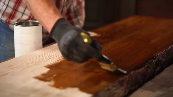 Man Is Applying Brown Lacquer on a Surface of Wooden Board, Painting Shop alt