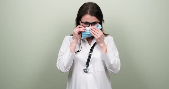 Portrait of Confident Mature Doctor Woman with Stethoscope, Female Puts on Medical Protective Mask