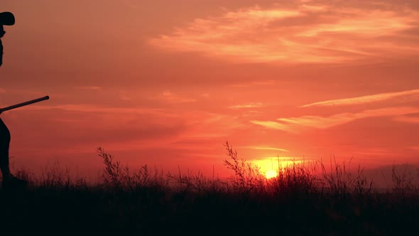 Girl in Fancy Dress Witch Holds a Broom Walks on the Field alt