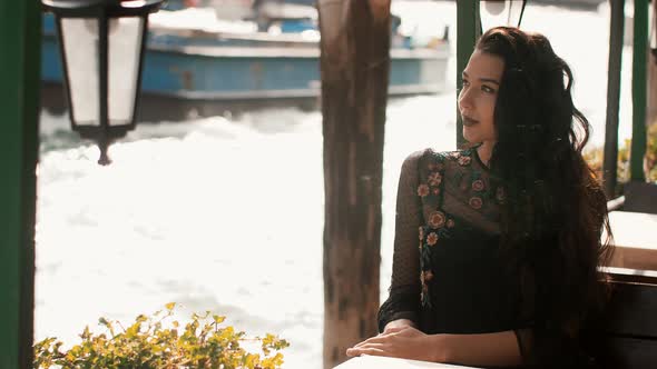Travel Tourist Woman in Cafe Against Beautiful View on Venetian Chanal in Venice, Italy. alt