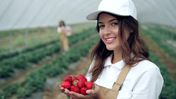 Smiling Young Woman Sniffing Fresh Strawberries alt