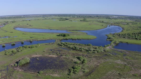 Scenic Aerial View of a River and Green Fields in a Countryside