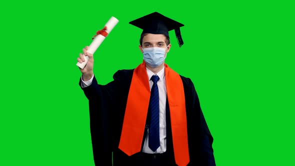 Graduating Student In Protective Mask Walking And Showing Diploma