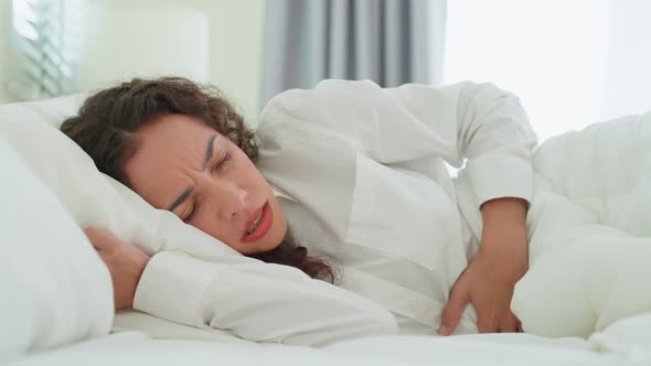 Latino beautiful sick girl in pajamas getting up from sleep in bedroom. alt