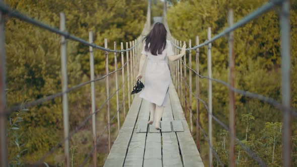 Woman in a Beautiful Dress, Runing on a Bridge in Woods alt