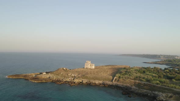 Aerial shot of coastline with a small castle on the beach